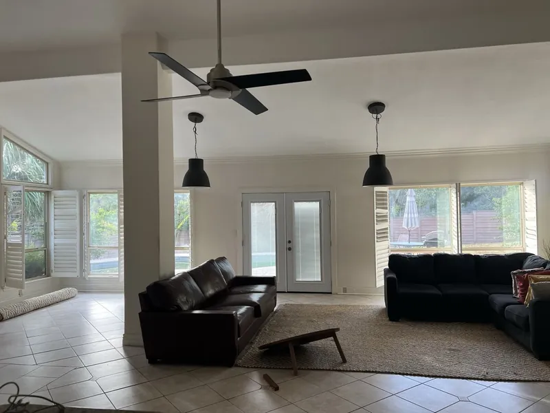 Living room before: two dark sofas and black pendant lights