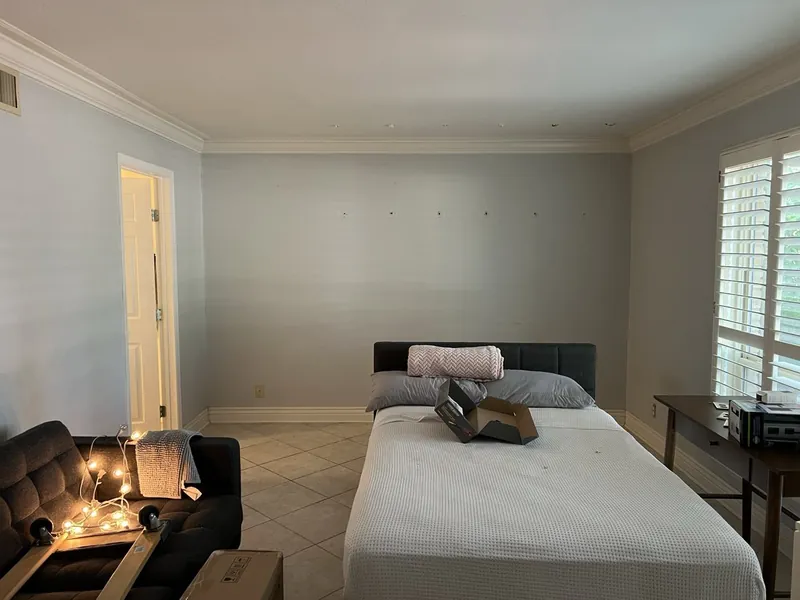 Cactus room before: bare gray walls and a plain bed