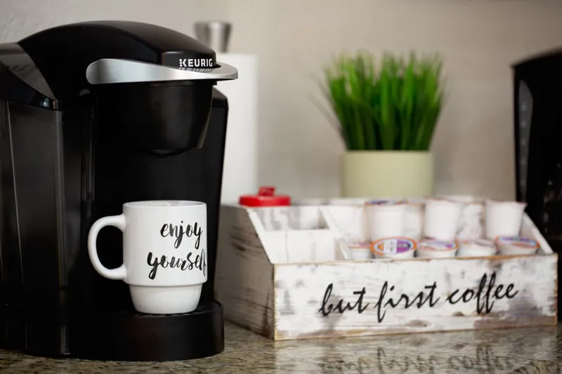A Keurig coffee bar with a But First Coffee sign