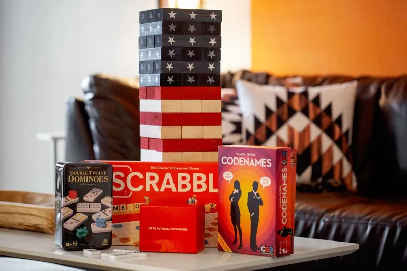Stars-and-stripes stacking blocks, Scrabble and Codenames on the game room table