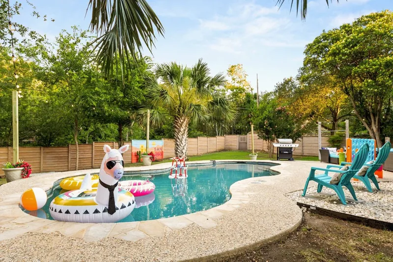The pool in 2025: a llama float, string lights and turquoise chairs