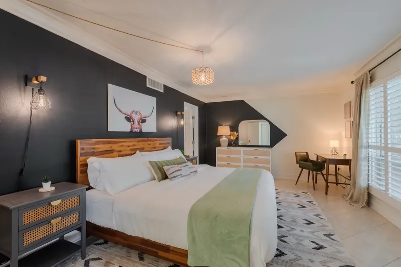 Longhorn room after: a black accent wall, a longhorn print and a wood bed