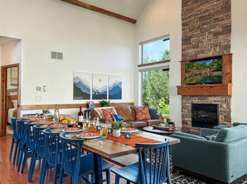 Fireplace wall after: a long dining table with teal chairs