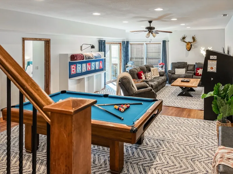 Rec room after: a blue-felt pool table, Branson sign and leather recliners