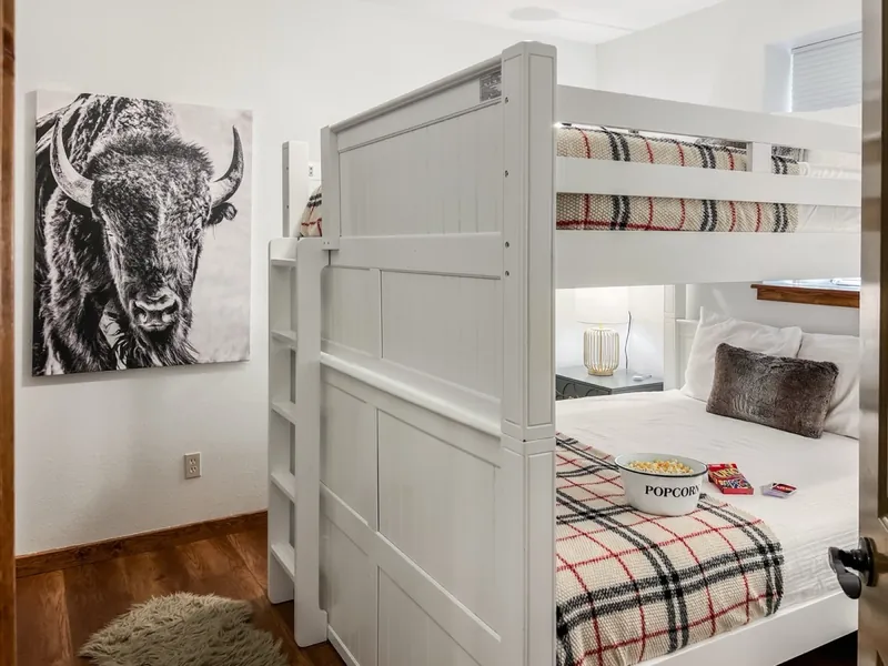 White bunk beds with plaid bedding and a bison print
