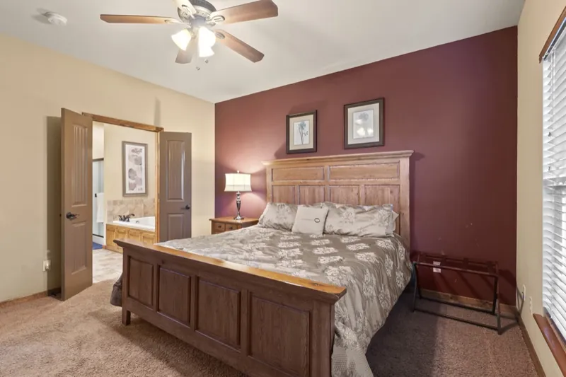 Primary suite before: burgundy accent wall and a heavy wood bed