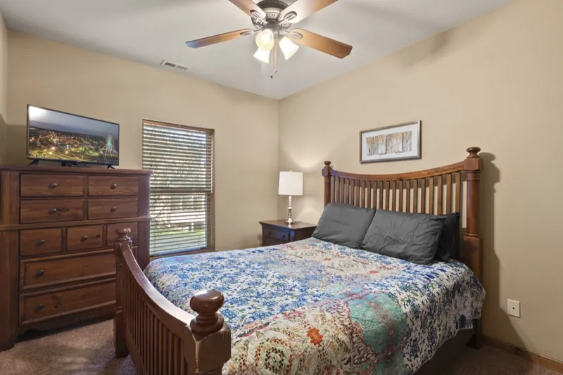 Downstairs bedroom before: floral quilt and wood furniture