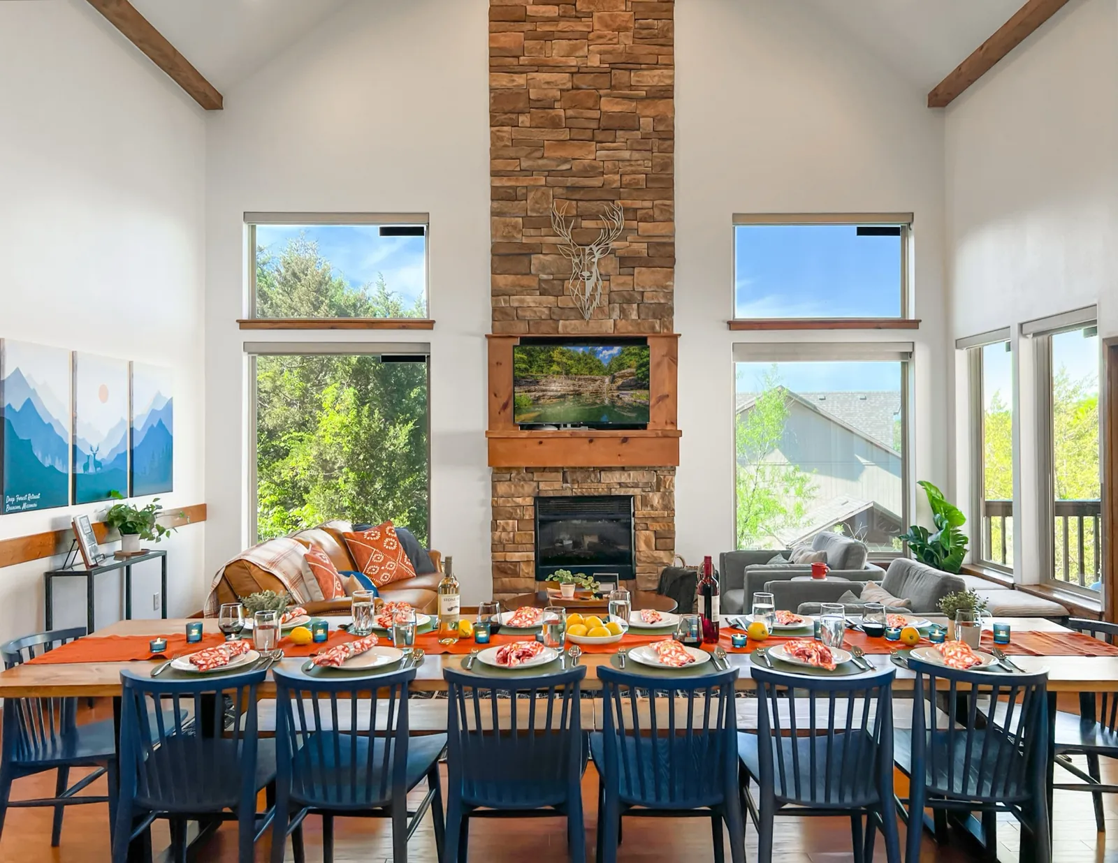 The great room set for a group dinner: one long table under the stone fireplace