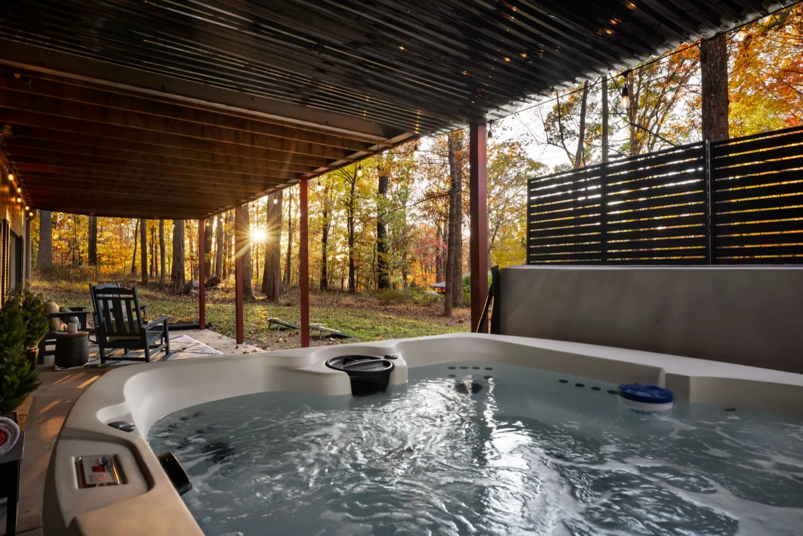 Hot tub after, with a slatted privacy screen and fall woods beyond