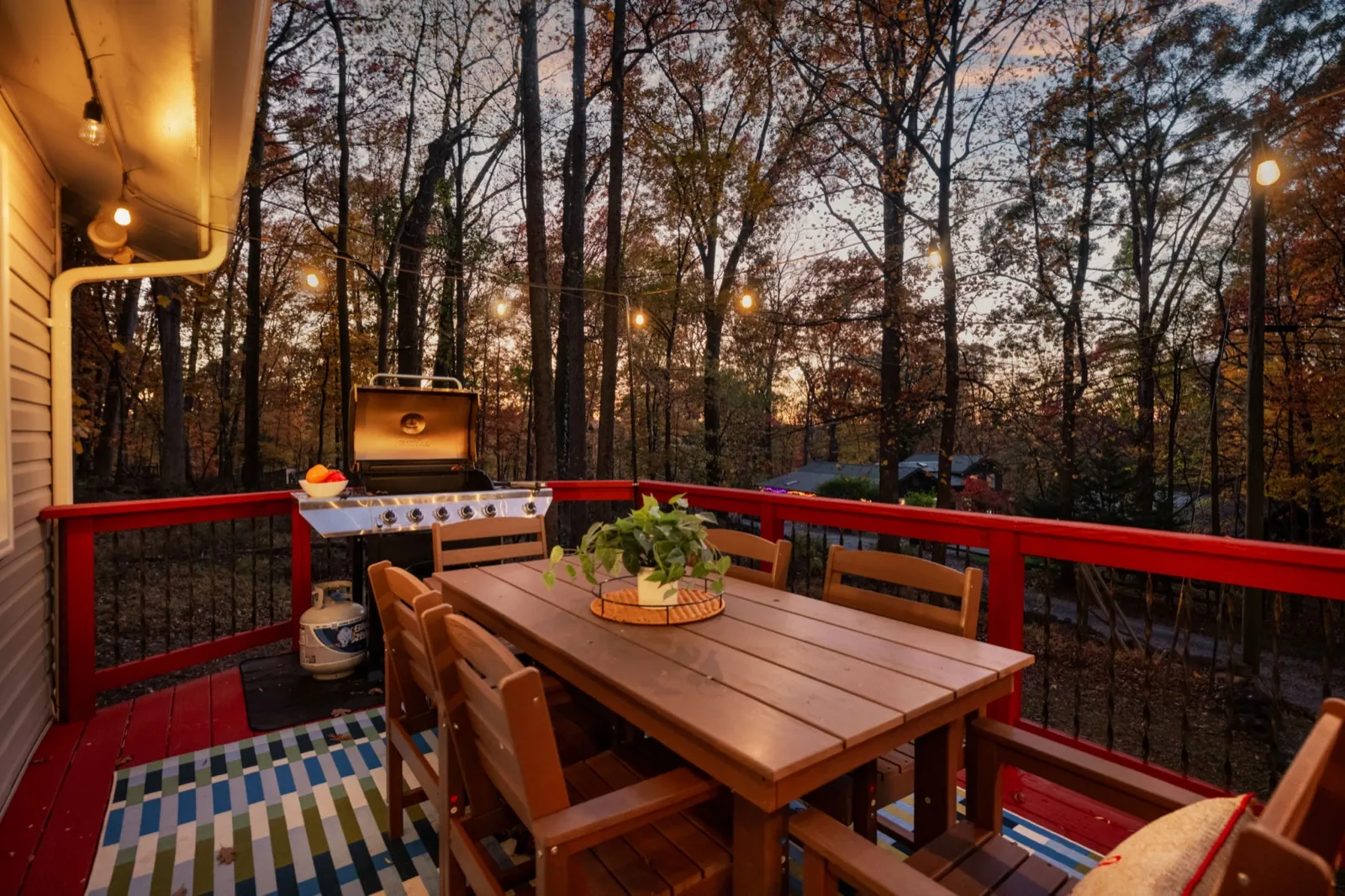 Deck dining table with a striped rug