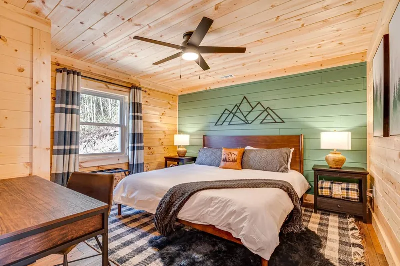 Mountain sage bedroom with a sage shiplap wall painted with a mountain line