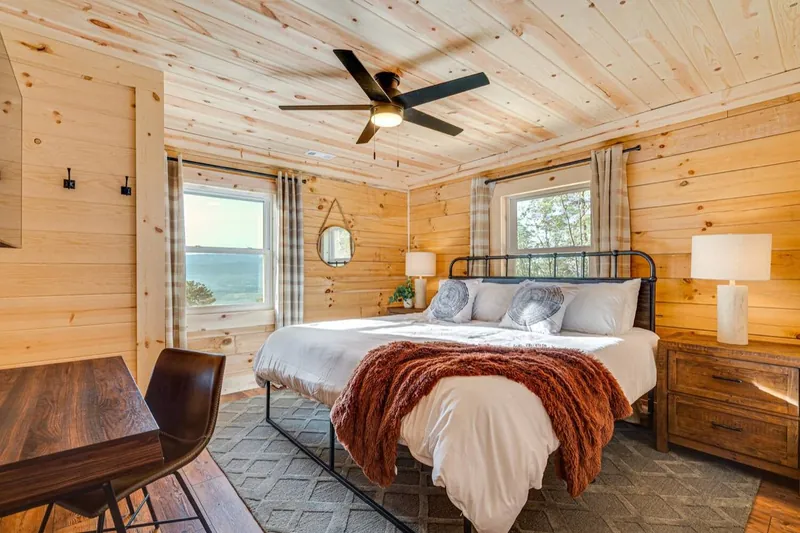 Iron and rust bedroom with a black iron bed and rust throw by the window