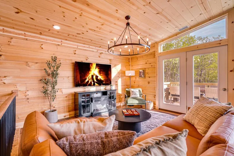 Finished living room with a cognac sectional and fireplace wall
