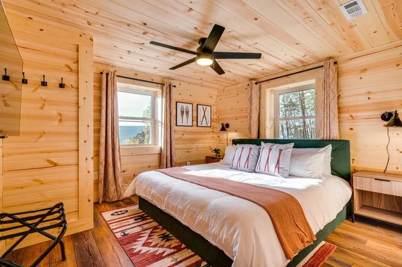Ski trail bedroom with green velvet, coral accents and vintage ski art