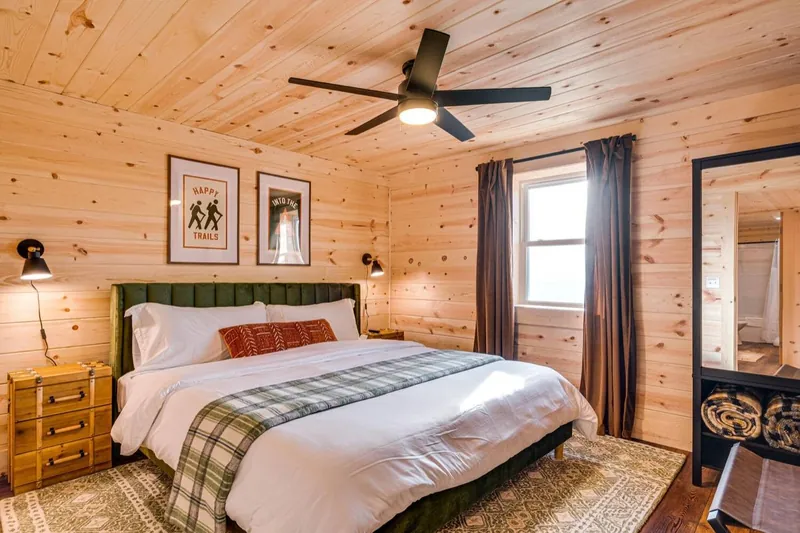 Forest plaid bedroom with a channel-tufted green headboard, plaid and trail prints