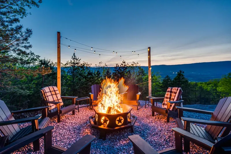 Firepit ringed with Adirondack chairs at dusk